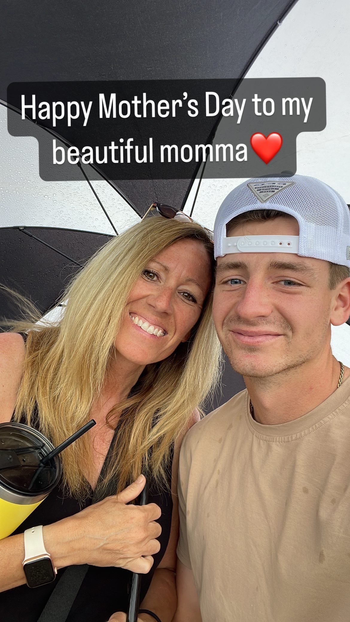 A woman and man smiling at the camera together, with a Mothers Day greeting overlaid on the image