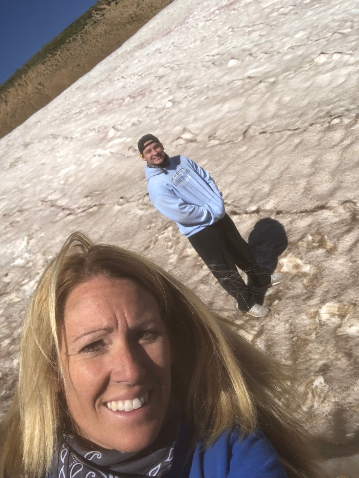 Woman smiling at camera with man standing behind her on a large white chalk cliff face